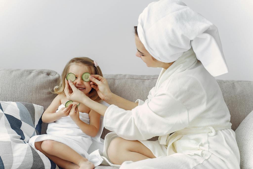 A relaxed mother enjoying a light moment with her daughter as part of self-care

