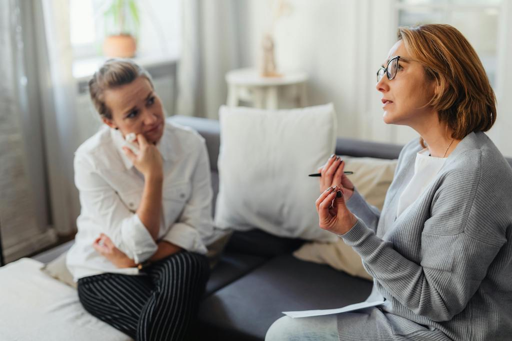 A certified wellness coach guiding a client through stress recovery techniques