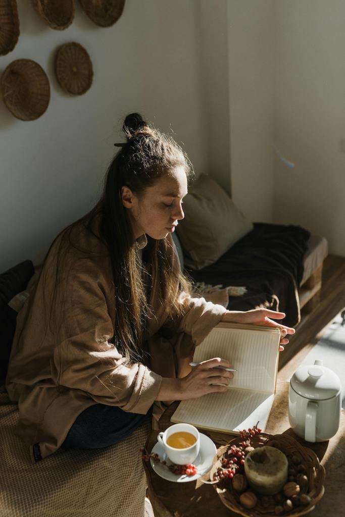 Woman journaling during morning light as part of a stress recovery routine