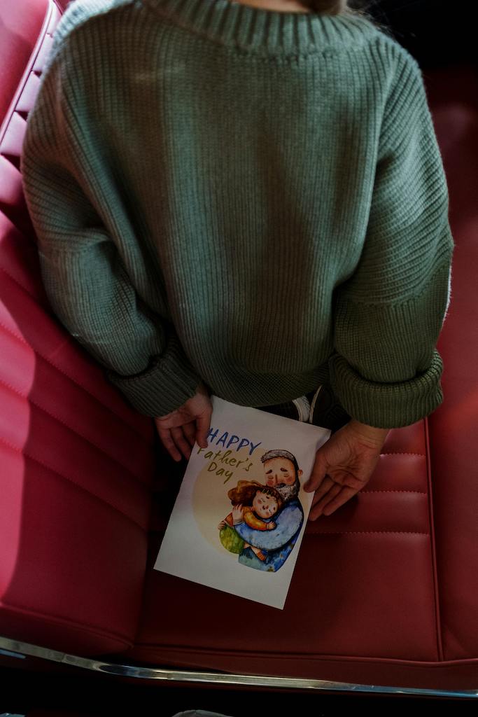 A child waiting patiently to give her Dad his Father's Day card