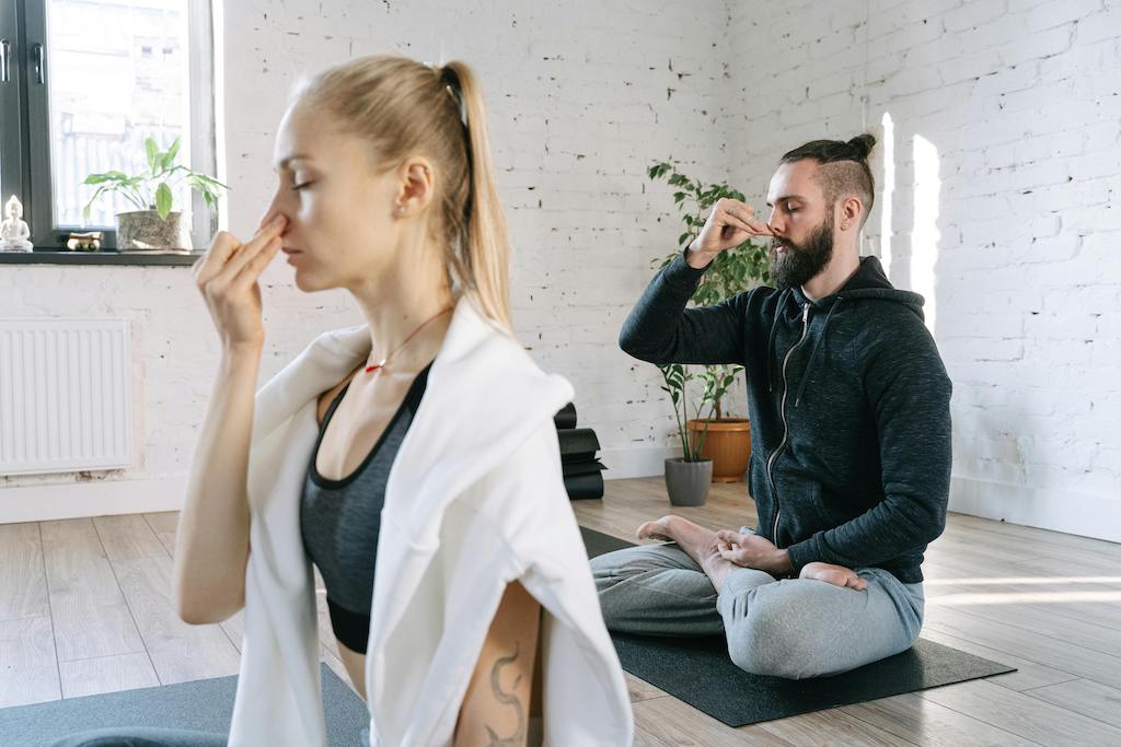 Alternate nostril breathwork technique in seated yoga posture.