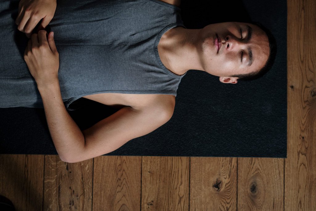 Man practicing belly breathing on a yoga mat for stress relief
