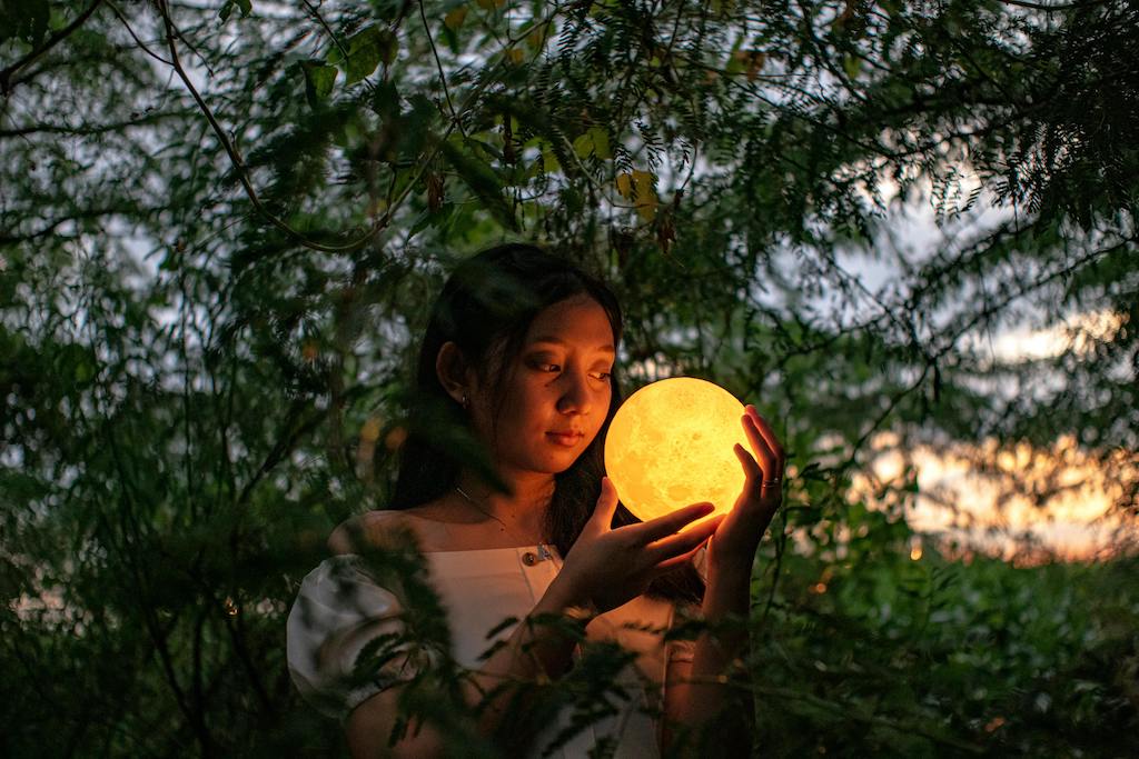 A woman meditating, gazing into the Supermoon.