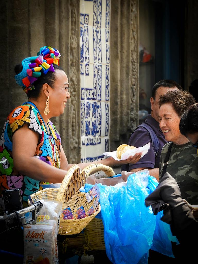 Woman serving tacos to locals