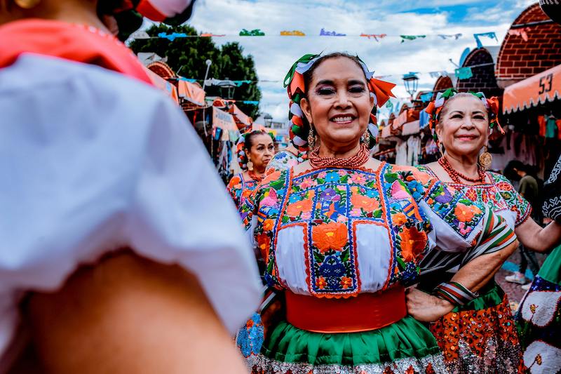 Folklórico dancers in colorful dresses celebrating.
